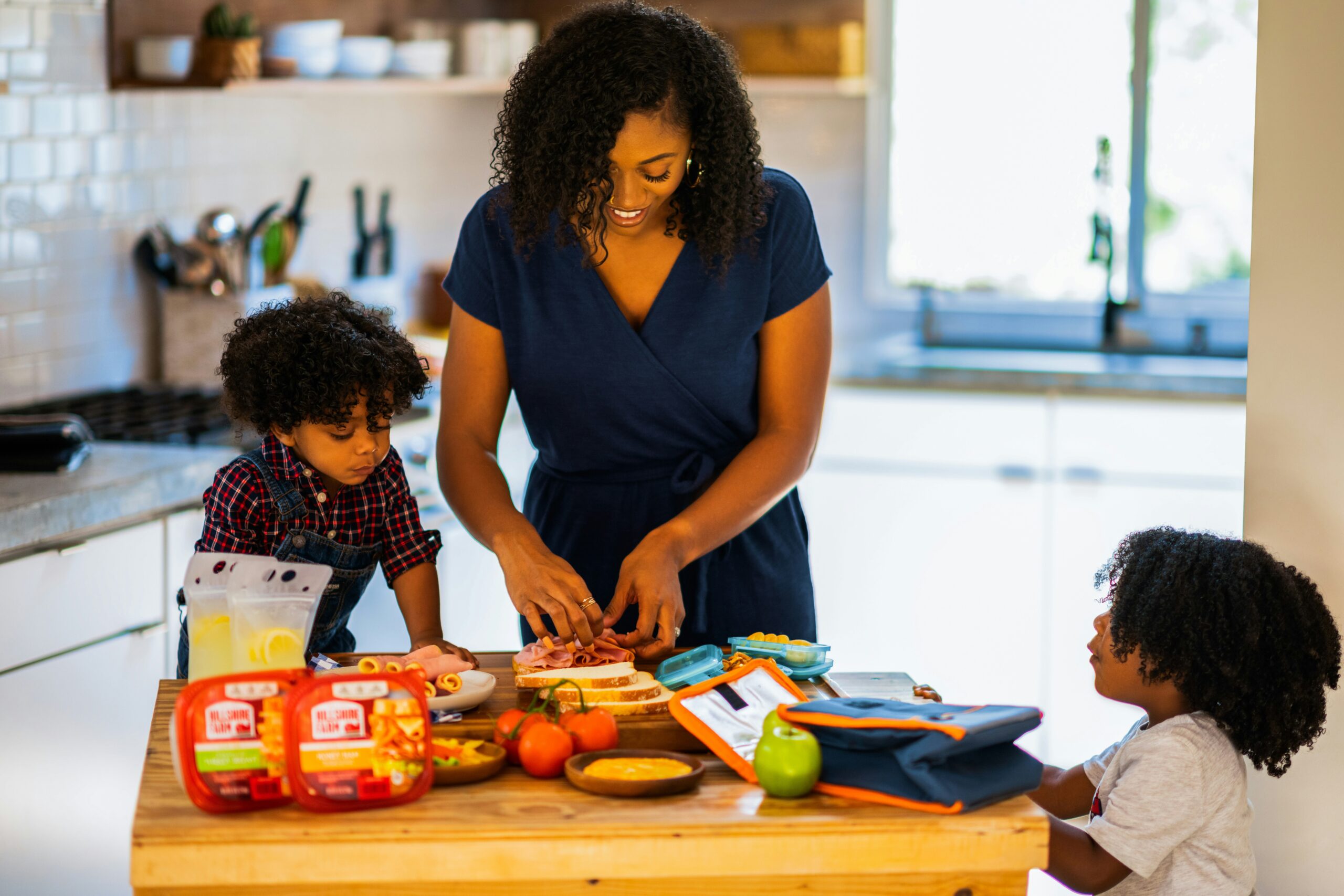 mom influencer agency. mom with two of her kids packing school lunches